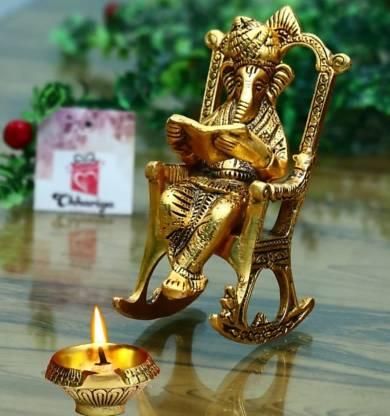 HomeSutra Golden Lord Ganesha Statue Sitting On A Rocking Chair And Reading Ramayan Showpiece