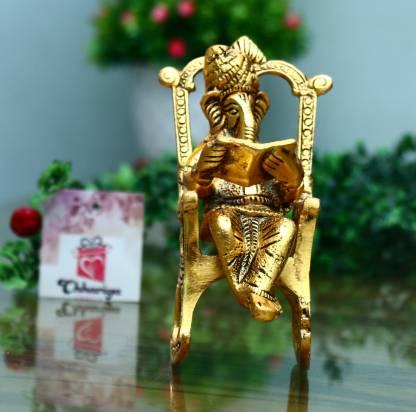 HomeSutra Golden Lord Ganesha Statue Sitting On A Rocking Chair And Reading Ramayan Showpiece