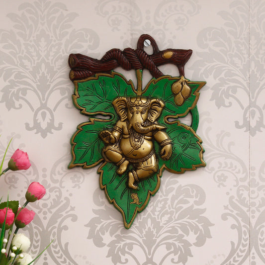 HomeSutra Dancing Golden Lord Ganesha on Green Leaf Metal Wall Hanging